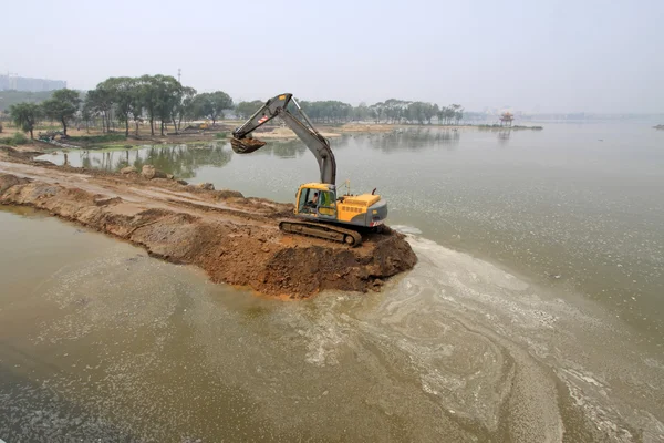 Escavadeira em um canteiro de obras de barragem — Fotografia de Stock