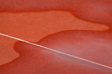 kırmızı plastik pist üzerinde su izleri
