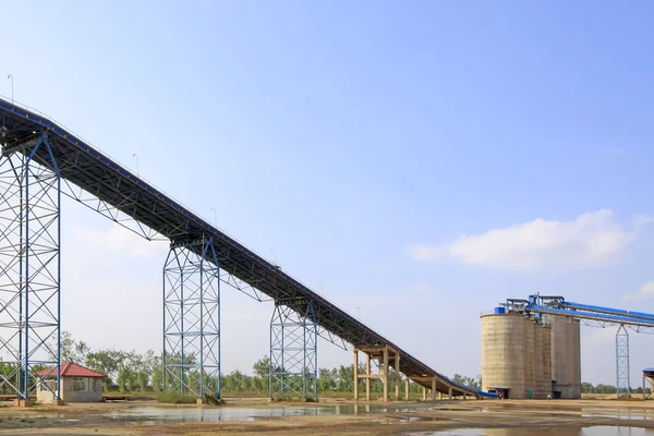 Grondstof magazijn en een transportband in een cementfabriek — Stockfoto