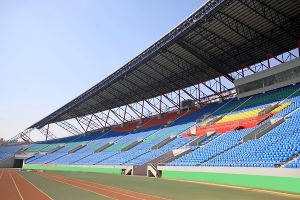 Rote Kunststoffbahn und Gebäude auf einem Sportplatz — Stockfoto