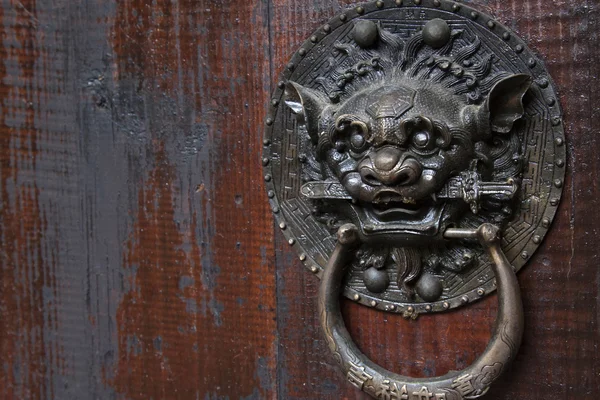 Metal beast head on the door panels in Phoenix Town, china — Stock Photo, Image