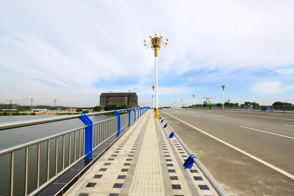 Highway bridge metallic baluster and building — Stock Photo, Image