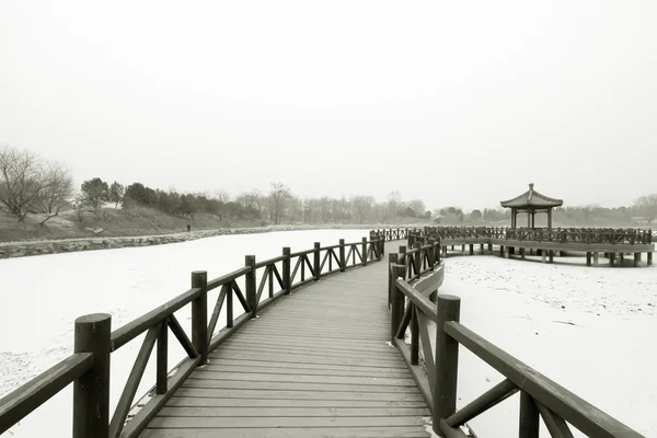 Holzbrücke im traditionellen chinesischen Stil im Schnee — Stockfoto