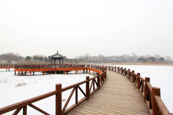 Holzbrücke im traditionellen chinesischen Stil im Schnee — Stockfoto