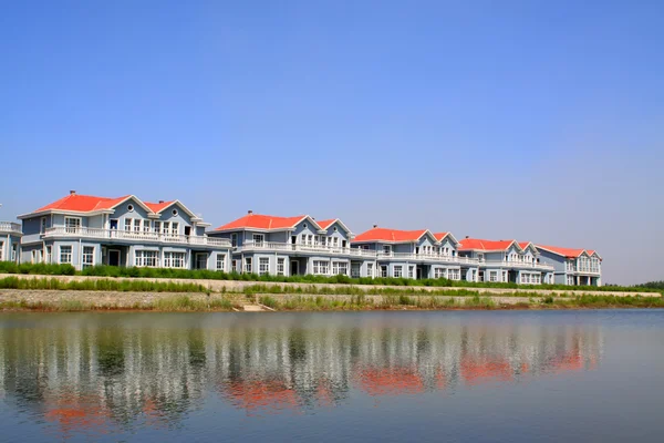 Red roof building at water 's edge — стоковое фото