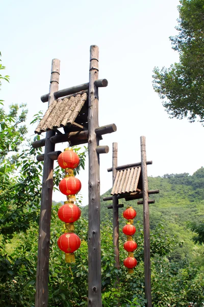 Farolillos rojos en árboles verdes en un lugar pintoresco — Foto de Stock