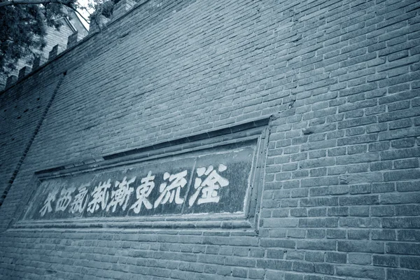 Classical text sculpture in the old grey wall in a park — 스톡 사진