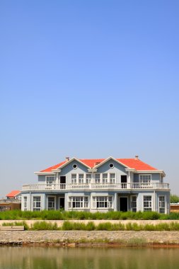 Kırmızı çatı su kenarında bina