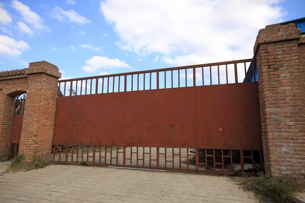 Czerwone ściany metalowe bramy niebieskie niebo — Zdjęcie stockowe