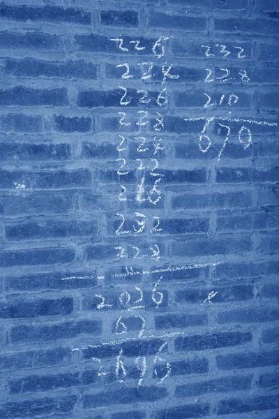 Números árabes en la pared gris — Foto de Stock