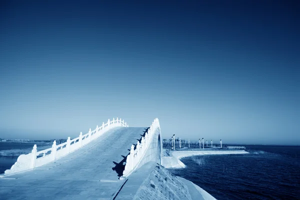 Pontes na água do lago, no céu azul — Fotografia de Stock