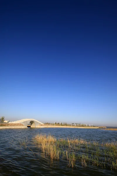 Ponts dans l'eau du lac, dans le ciel bleu — Photo