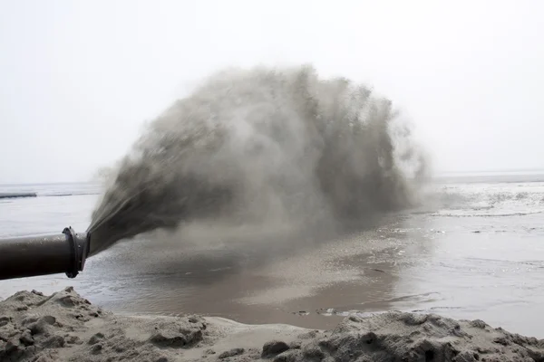 A areia soprando fez a engenharia de terra pelo mar Fotografia De Stock