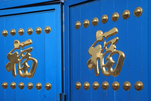 Caracteres chineses no portão azul — Fotografia de Stock