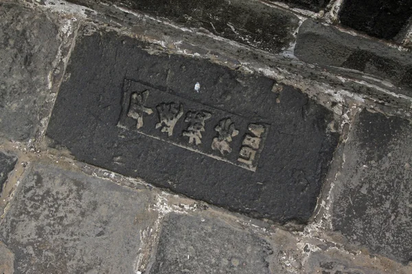Кирпич в стене с иероглифами — стоковое фото