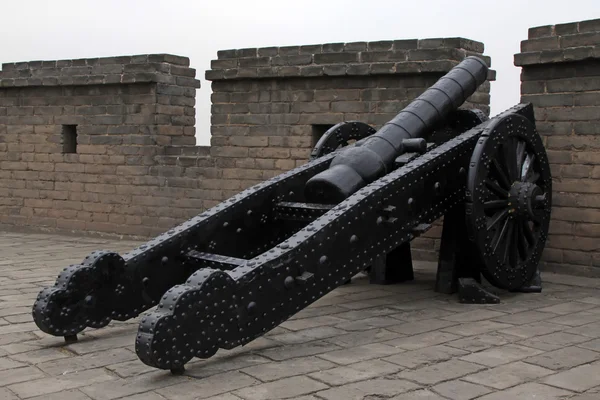 Железная пушка у стены в Китае — стоковое фото