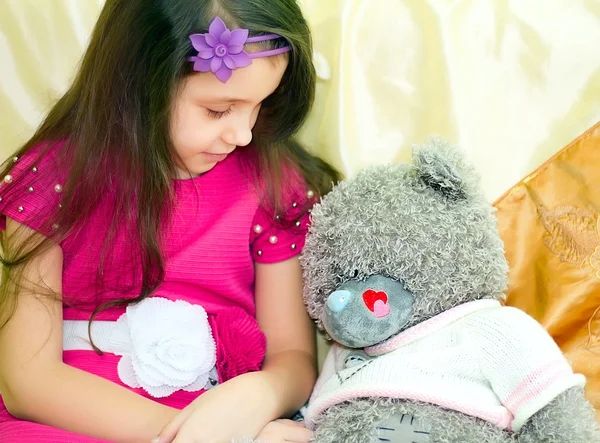 Mädchen schaut Teddybär an — Stockfoto
