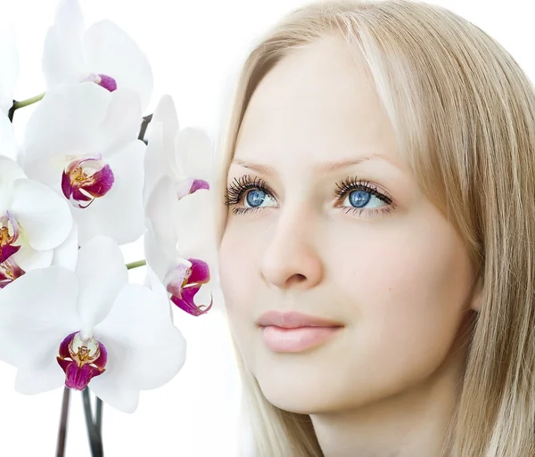 Cara de mujer de primer plano con orquídea blanca — Foto de Stock