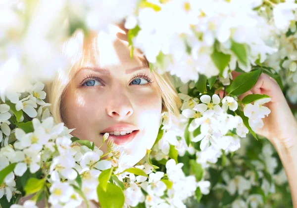 Primo piano bella donna tra i fiori di melo — Foto Stock