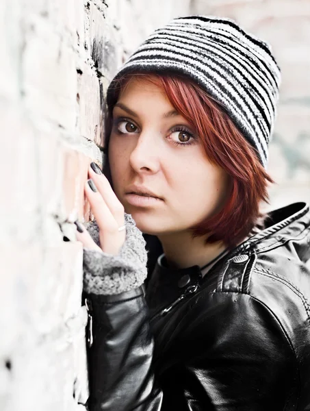 Retrato de mujer joven en una pared vieja de ladrillo — Foto de Stock