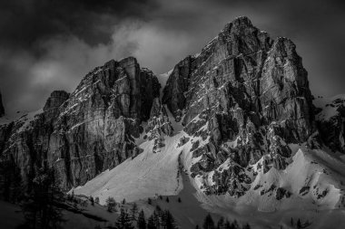 Batan güneşin aydınlattığı etkileyici dolomit duvarının siyah ve beyaz görüntüsü