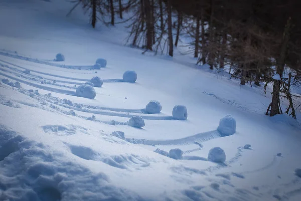 Effetto di spostamento inclinato delle palle di neve a forma di ruota formate rotolando lungo un pendio — Foto Stock