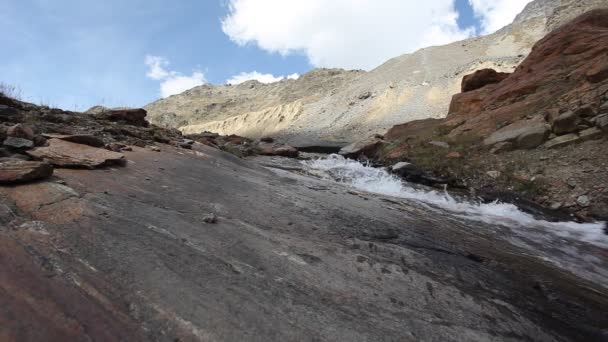 Horolezec brodící se vysokým horským ledovým potokem — Stock video