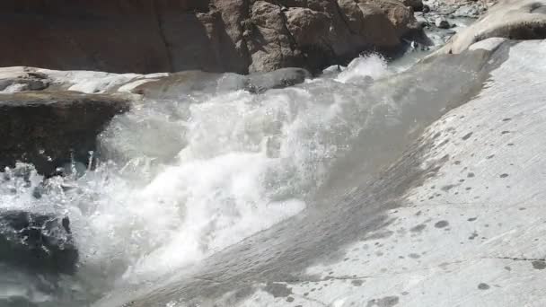 Wodospad w dzikiej górskiej rzece przepływający przez kamienne głazy — Wideo stockowe