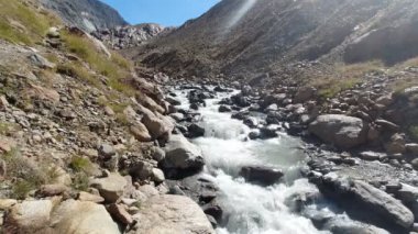 Buzul kaynaklı dağ nehri taş kayaların arasından akıyor.