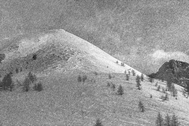 Karlı zirvenin mangal kömürü tekniğiyle karlarla çevrili bir resim.