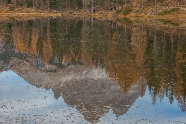Reflejo de montaña dolomítica y alerces de colores otoñales en el lago — Foto de Stock
