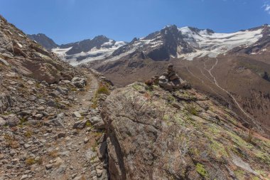 Arka planda Palla Bianca 'nın zirveleri ve buzulları olan dağ yolu