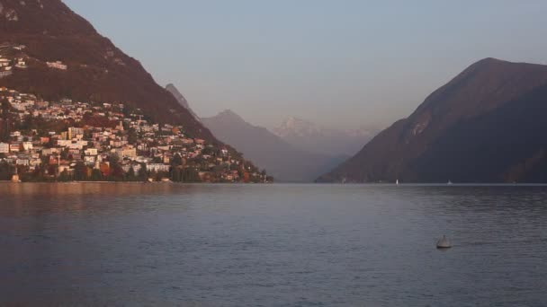 Lago Lugano ao pôr-do-sol com montanhas cobertas de neve na fronteira suíça italiana — Vídeo de Stock