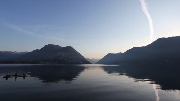 Sunrise at Lake Lugano in autumn winter with reflections on the water — Stok video