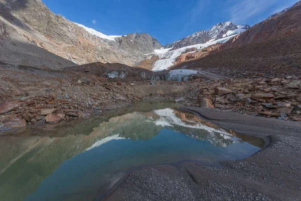 Dağların yansıdığı suları olan buzul cephesinin yakınındaki yüksek dağ göleti. Vallelunga, Alto Adige, İtalya