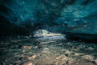 Awesome blue ice cave carved into the Vallelunga glacier crossed by a stream. The glacier is in rapid retreat caused by global warming, Alto Adige, Italy