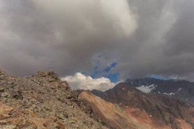 Çapraz ve görkemli Punta del Lago Bianco zirvesi arka planda bulutlarla kaplı, Vallelunga, Alto Adige Sudtirol, İtalya