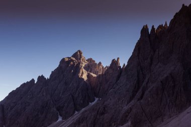 Dolomite tepeleri ve Popera zirvesinin tıkalı duvarları Comelico Bölgesi, Dolomitler, İtalya 'da güneşin son ışınları tarafından aydınlatılmıştır.