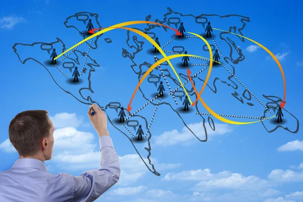 Man drawing on a world map on a glass wall — Stock Photo, Image