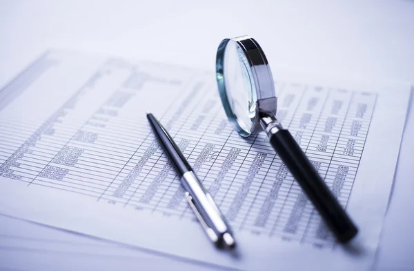 Pengar, penna, förstoringsglas och den finansiella rapporten — Stockfoto