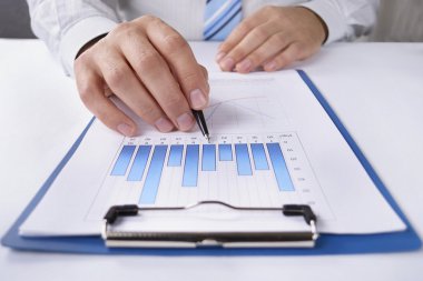 onun masasında bir grafikte çalışma iş adamı