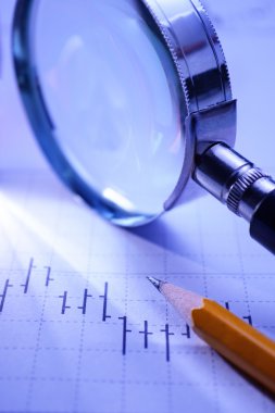 Graph, magnifying glass and pencil