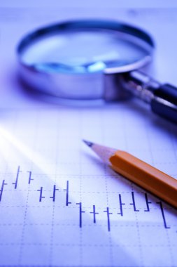 Graph, magnifying glass and pencil