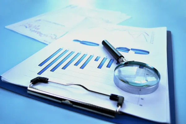 Magnifying glass with a bar graph — Stock Photo, Image