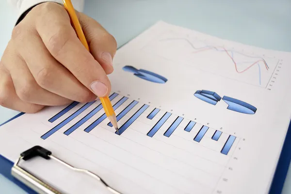 Man med en penna som arbetar på en graf — Stockfoto