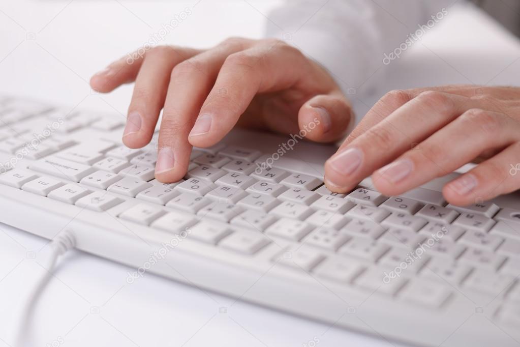 Male hands typing on a computer keyboard
