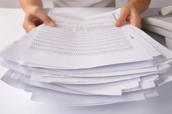 Mãos segurando um lote de papelada solta — Fotografia de Stock