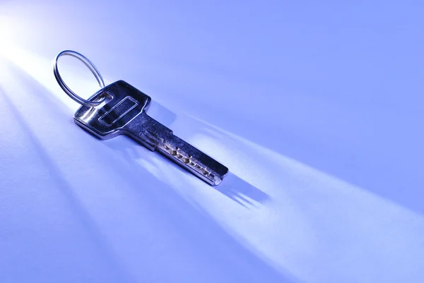 Key lying in a shaft of light — Stock Photo, Image