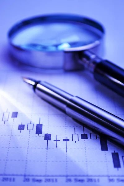 Pen and magnifying glass on a graph — Stock Photo, Image