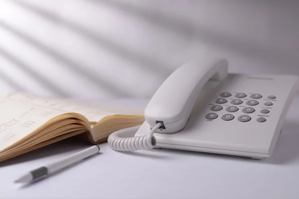Telefon mit offenem Buch — Stockfoto